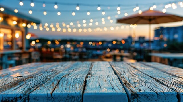 Weathered table foreground on a blurry outdoor restaurant patio at dusk