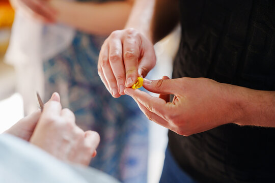 Closeup of parents hands cutting baby hair during orthodox church baptism