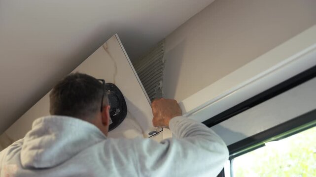 Worker applies ceramic tile to glue it to wall. renovation, building preparation, and construction tools 