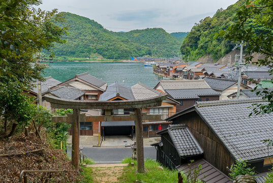 鳥居越しに望む伊根の舟屋と湾の風景