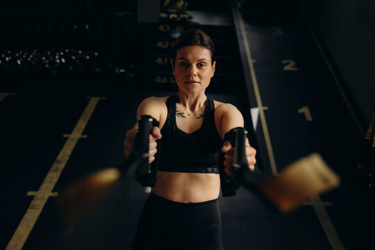 Woman exercising using trx straps at gym