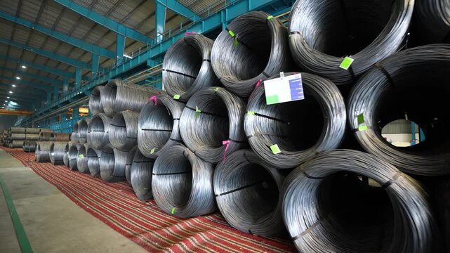large coils of steel wires in a factory. spools of wound wires cables for production in manufacturing factory. copper wire making process. wire drawing at factory. bronze coating thin wire running.