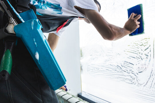 Experienced Professional Window Cleaner with Tools Washing Soapy Glass