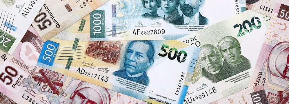 Mexican peso money banknotes pile on table. Mexico bills of MXN currency close up
