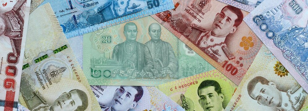 Thai baht money banknotes pile on table. Thailand bills of THB currency close up. Concept of economy