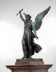 Obraz premium Elegant bronze archangel statue isolated on white, highlighting classical craftsmanship, spirituality, faith, and timeless religious art traditions.