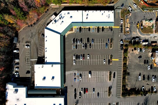 Aerial nadir drone view of suburban retail shopping center with autumn foliage and parking lot &mdash; Roxboro, North Carolina