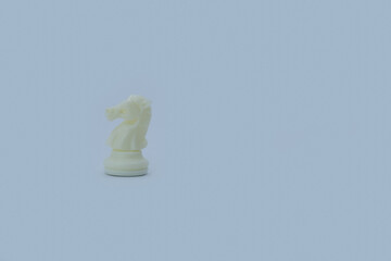 White Plastic Chess Knight on Gray Background with Copy Space © Юрий Несмашный