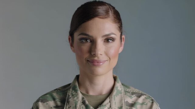 Cam starting soldier facing cam softening smile for studio portrait wearing digital camo tan tee