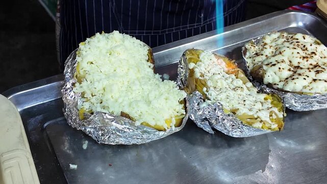 Blowtorching Cheese on Stuffed Baked Potatoes at Street Food Market