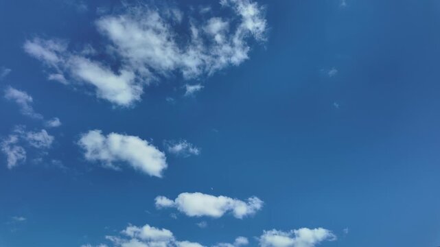 Puffy fluffy white cloud n cotton candy cumulus cloudscape moving on beautiful sunny clear blue sky background in summer sunlight n sun ray at sunshine day, slow motion 4k cinemagraph b-roll TimeLapse