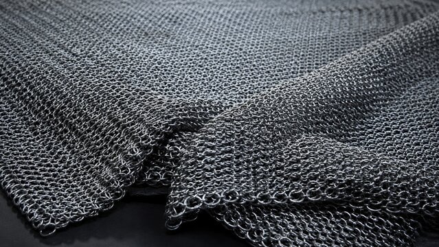 Close-up of overlapping steel chainmail rings forming textured medieval chain mail fabric