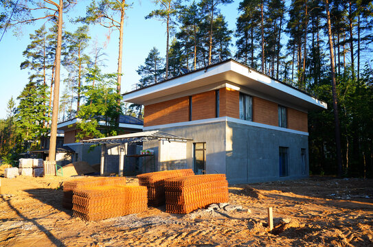 New houses under construction in forest area during morning light. Home building. Housing development outside city. Construction of family house in suburb. Housing in suburban.