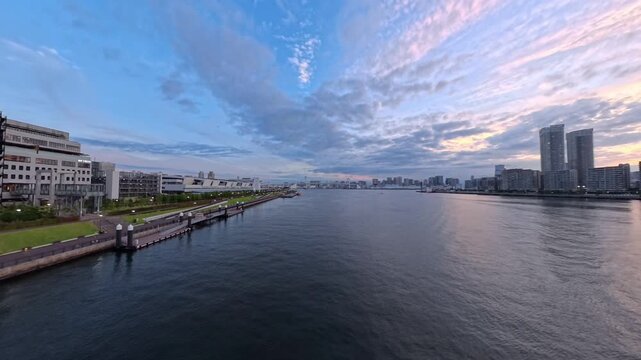 TOKYO, JAPAN - JUNE 2026 : Sunset high angle tracking shot of luxury skyscraper apartments and modern waterfront in Toyosu area. Real estate, futuristic city and metropolitan living concept video.