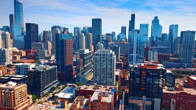 Downtown skyscrapers and mixed architecture, Chicago, Illinois. Glass towers, brick mid rises and Willis Tower rising against blue sky with wispy clouds.