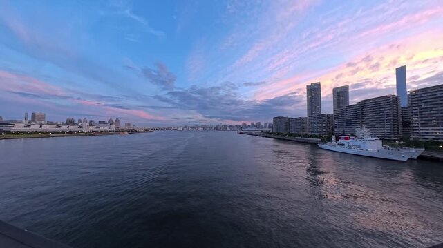 TOKYO, JAPAN - JUNE 2026 : Sunset high angle tracking shot of luxury skyscraper apartments and modern waterfront in Toyosu area. Real estate, futuristic city and metropolitan living concept video.