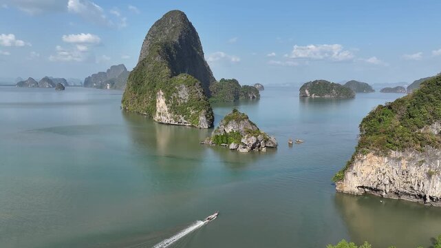 Long-tail boat cruising through phang nga bay thailand