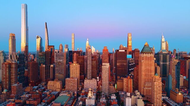 Midtown Manhattan skyline with supertall towers at dusk, New York. Central Park South supertalls and mixed-era buildings under a blue-to-pink gradient sky at twilight.