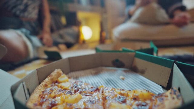 Friends sharing a fresh pizza from a delivery box at home