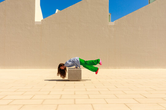 Woman Balances in Outdoor Space Under Clear Sky