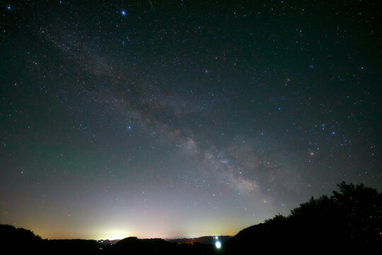 Summer Milky Way stars and landscape scenery silhouettes.
