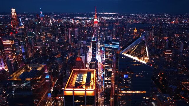 Architectural details of a triangular skyscraper roof, New York City. Illuminated glass peak of a modern tower surrounded by glowing midtown streets.