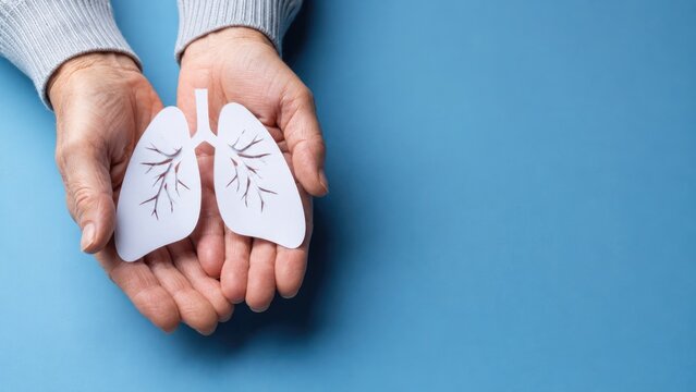 Paper lungs in elderly hands on blue background representing respiratory health pulmonary care and lung disease awareness