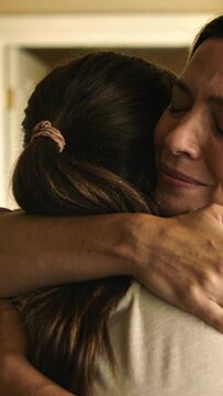 Vertical video: Hugging mom and daughter after arrival at door, with pink scrunchie and pale tops