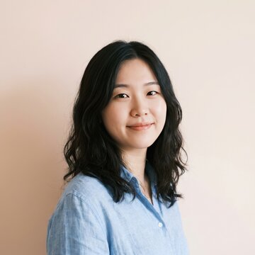 A Young East Asian Woman Wearing A Light Blue Linen Casual Shirt