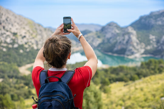 Mallorca, Spanien: Wanderung im Norden der Insel, Serra de Tramuntana zum Puig des Tossals Verds - Wanderin fotografiert mit Handy den Cuber Stausee