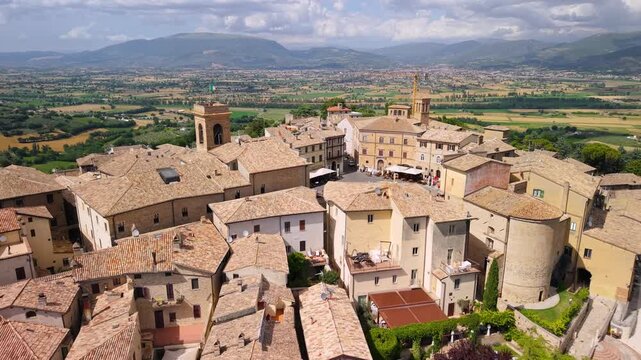 Montefalco Sagrantino wine Umbria Italy 4k drone viticulture enotourism reveal. Aerial backward view of medieval borgo town hilltop village green fields vineyards agriculture b-roll establishing