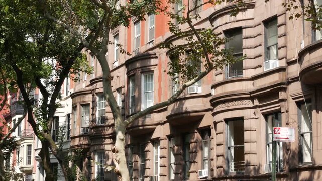 New York City townhouse buildings, brownstone row houses in Manhattan or Brooklyn, United States of America. Classic buildings on residential district street. Real estate property. Rowhouse townhome.