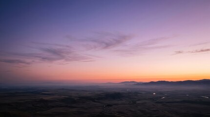 Fototapeta premium Vibrant Sunset Sky Over Rolling Hills and Distant Mountains.