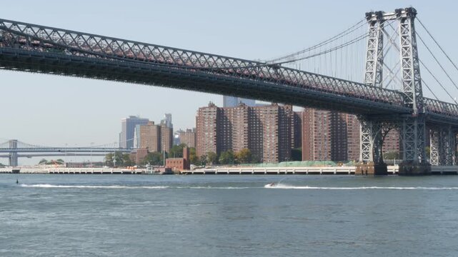 Williamsburg Bridge in Brooklyn, New York City, United States. Transport metallic bridge near Marcy Av subway station and Domino park in Williamsburg. World Trade Center skyscraper tower on Manhattan.