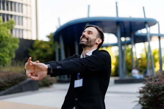 Happy businessman stretching on a city street break
