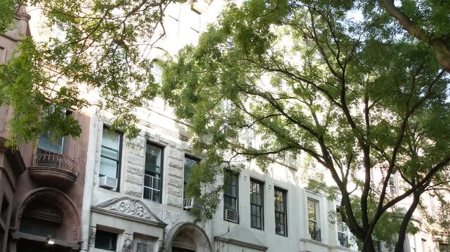 New York City townhouse buildings, brownstone row houses in Manhattan or Brooklyn, United States of America. Classic buildings on residential district street. Real estate property. Rowhouse townhome.
