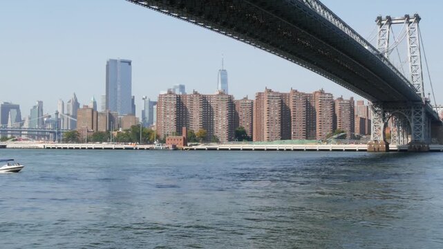 Williamsburg Bridge in Brooklyn, New York City, United States. Transport metallic bridge near Marcy Av subway station and Domino park in Williamsburg. World Trade Center skyscraper tower on Manhattan.