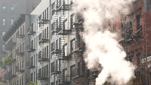 New York City urban residential buildings architecture, Manhattan classic street, United States of America. Typical red brick house, real estate property, USA. Fire escape metallic ladder. Hot steam.