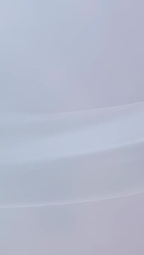 Vertical video: Starting animation, translucent ribbon shifting upward as pale blue phone wallpaper