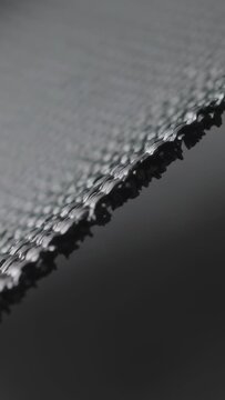 Vertical video: Shifting camera focusing, revealing macro knitted edge in studio for stitch detail