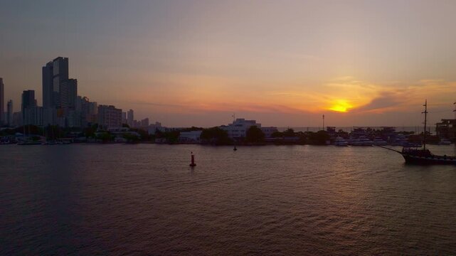 Atardecer sobre la bah&iacute;a de Cartagena con reflejos dorados y embarcaciones en el agua horizonte puerto barcos edificios horizonte  Colombia