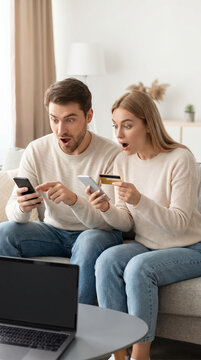 Surprised couple looking at smartphone at home