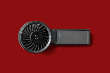 Top down view of black mini handheld fan with LED display on red isolate background, Easy for Di-Cut PNG image © punpolpoke