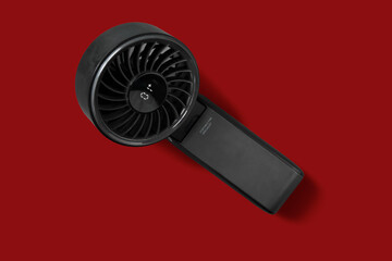 Top down view of black mini handheld fan with LED display on red isolate background, Easy for Di-Cut PNG image © punpolpoke