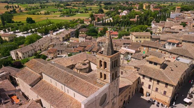 Bevagna Umbria Italy 4K Drone Aerial. Dynamic flight turn over historic center with medieval towers churches plazas and scenic green fields background. Authentic hidden gems travel asset footage