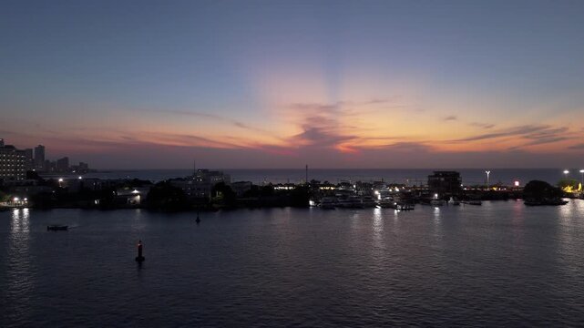 Atardecer sobre la bah&iacute;a de Cartagena con reflejos dorados y embarcaciones en el agua