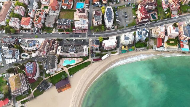 Aerial view of a coastal resort town. Top-down view of a seaside city with hotels and residential complexes. View of the Black Sea.