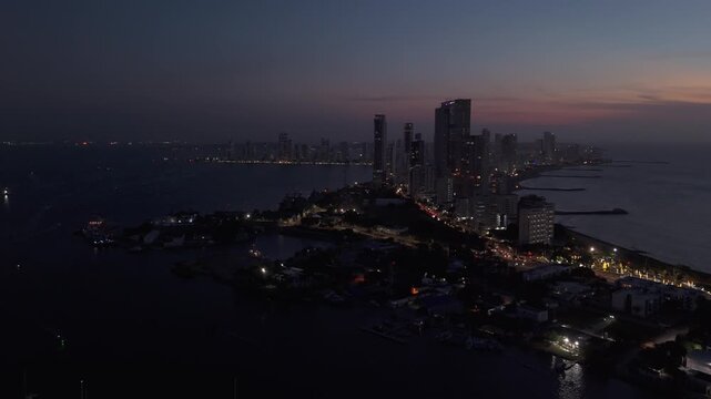 Skyline costero de Cartagena de Indias al anochecer con rascacielos frente al mar paneo ciudad 