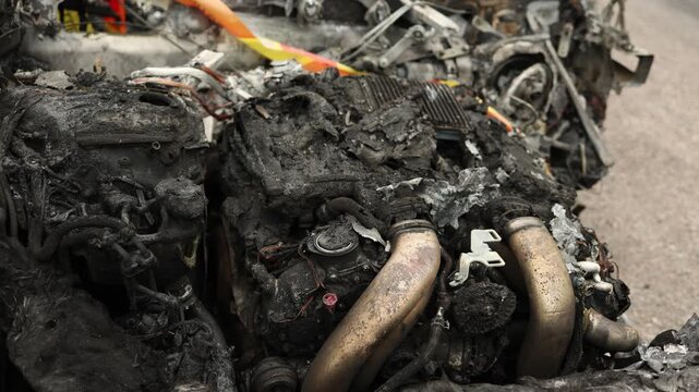close up of a powerful engine inside a burned vehicle revealing severe fire damage melted components and the aftermath of a destructive automotive incident