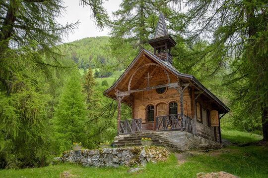 The quaint Chapel of Planchouet stands peacefully amidst greenery reflecting the harmonious blend of architecture and nature in the Swiss Alps